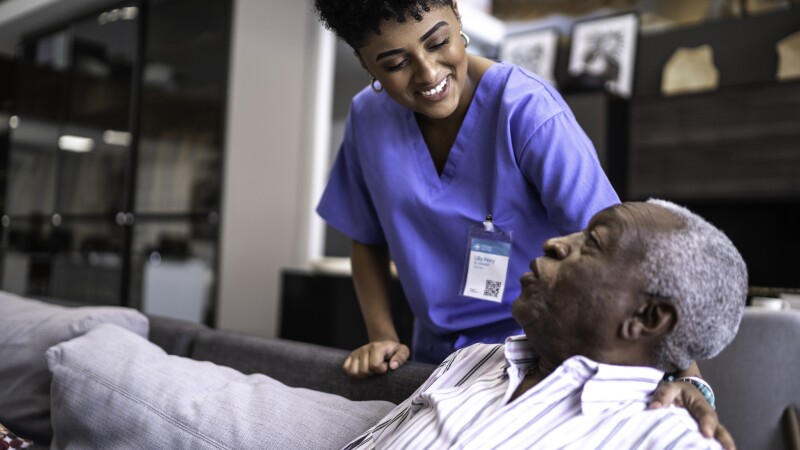 Female nurse taking care of a senior man at home