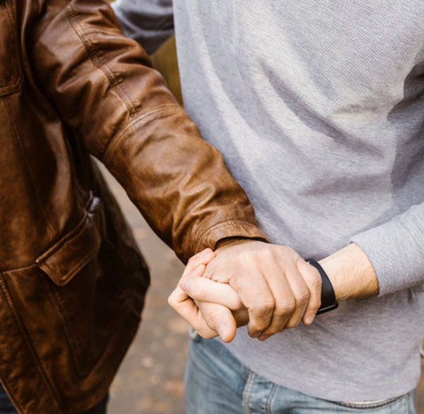 Midsection of young man holding hand of retired senior father