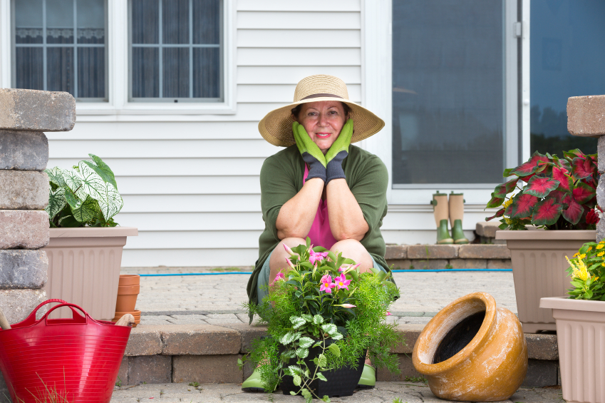 Elderly woman pausing while potting up plants