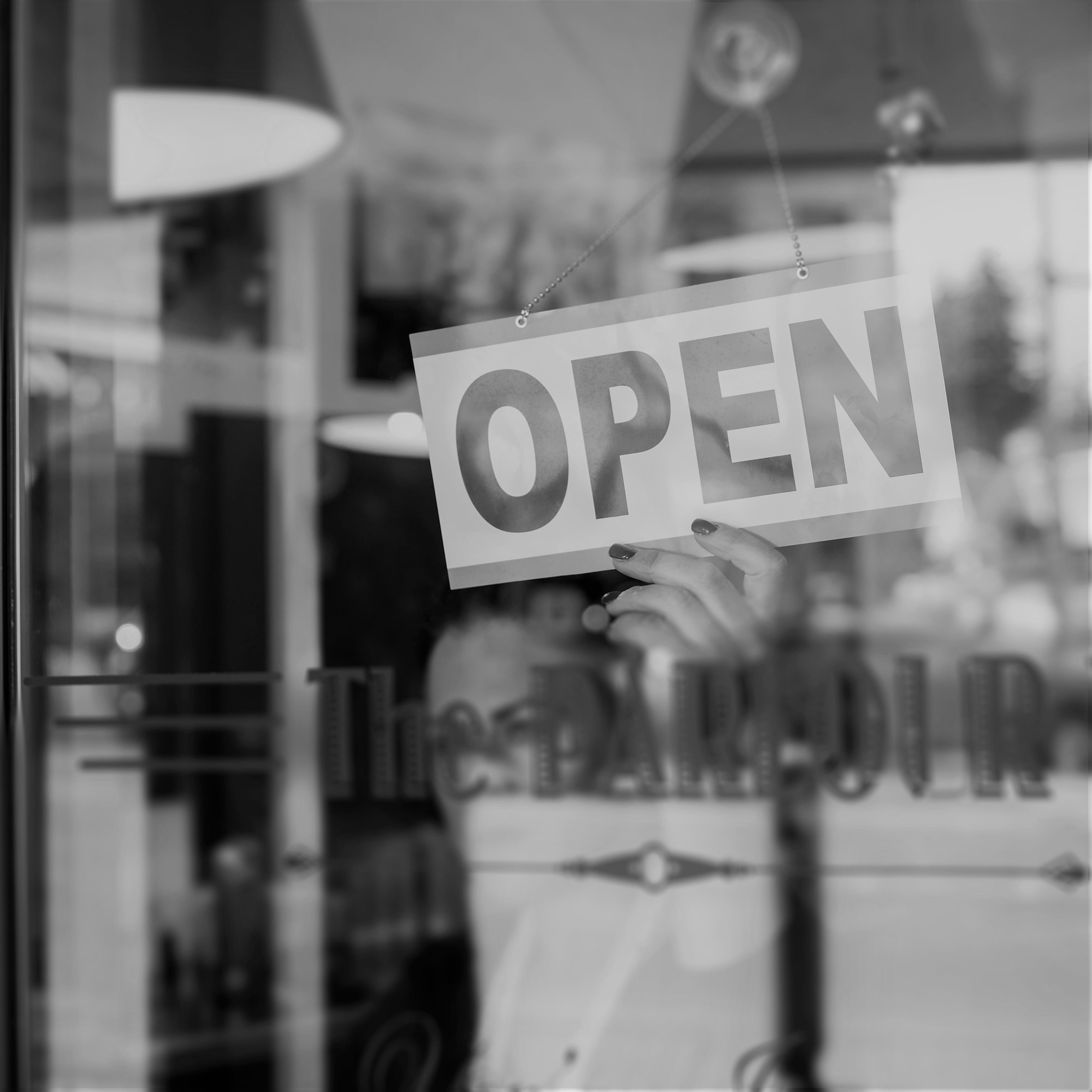 Hairdresser turning open sign in retro barbershop window