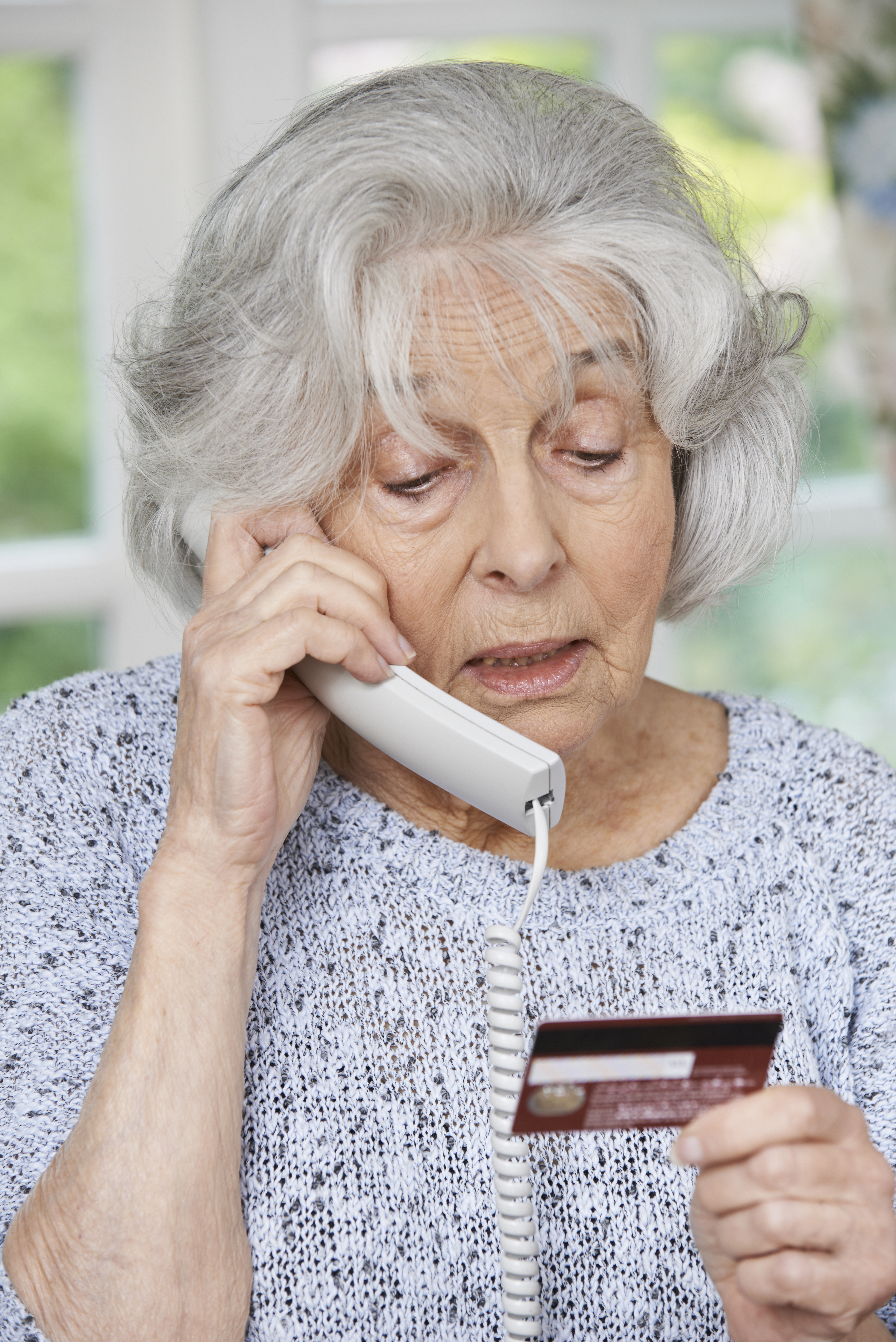 Senior Woman Giving Credit Card Details On The Phone