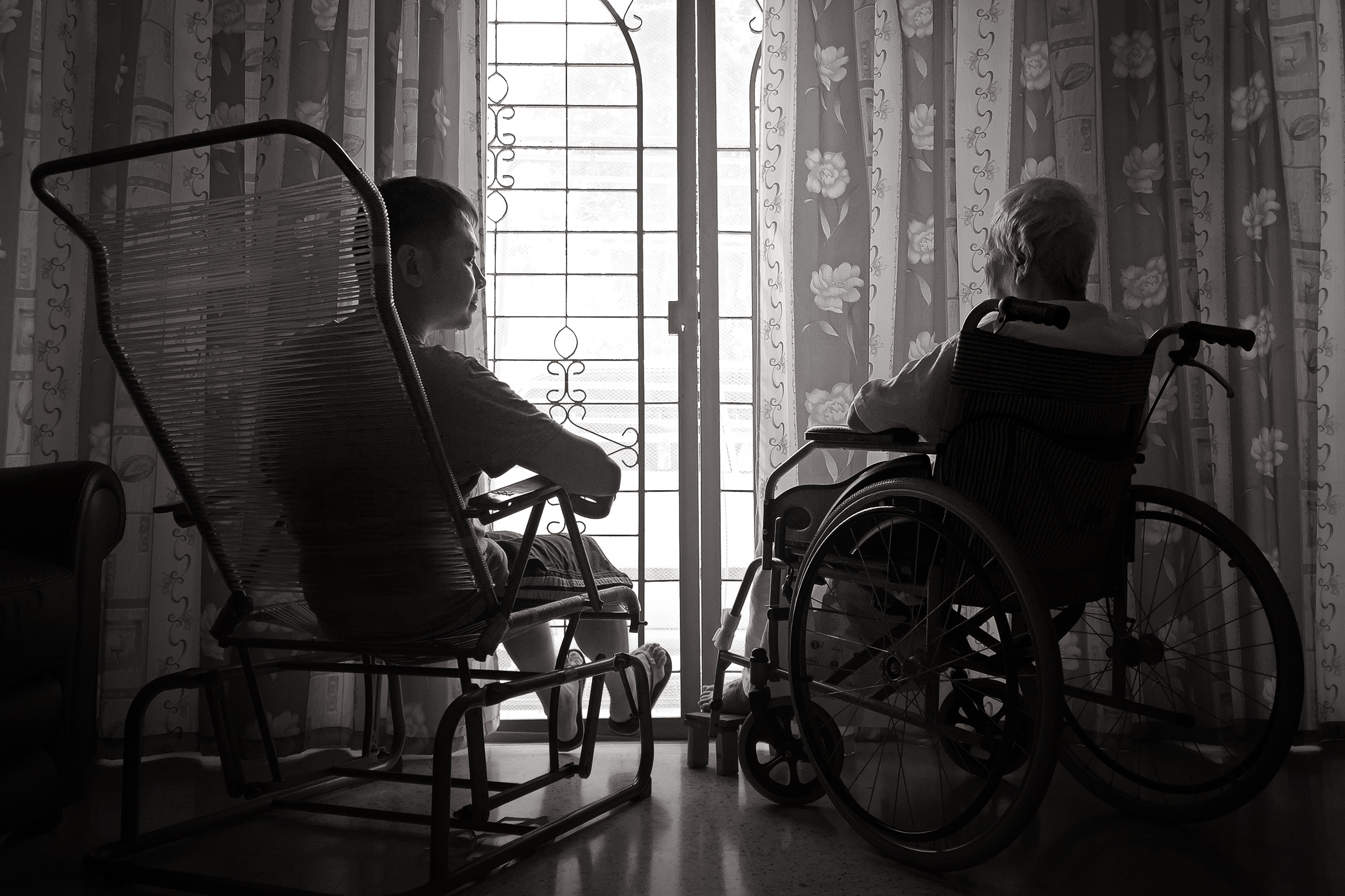 Rear View Of Men Sitting By Window