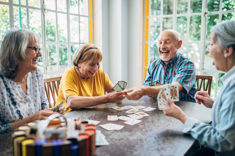 Old people having fun playing cards in nursing home