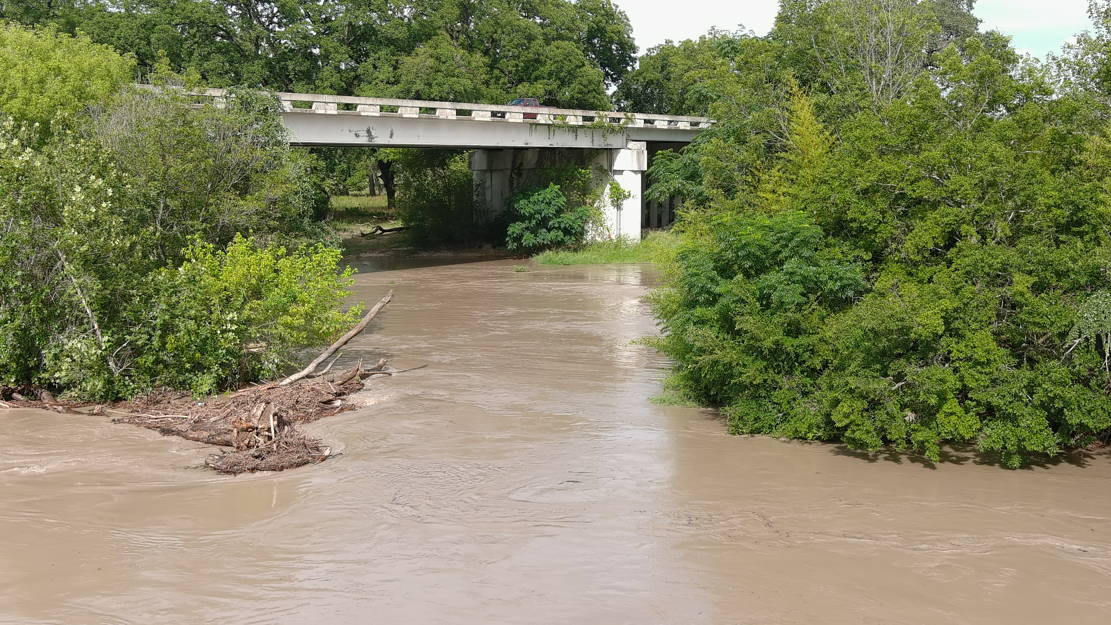 A picture taken with a drone right above the old bride that goes into town with the new bridge in the background. The old bridge was flooded quite often and while still in place was replaced by the highway 87 bridge that still has a couple of ft space