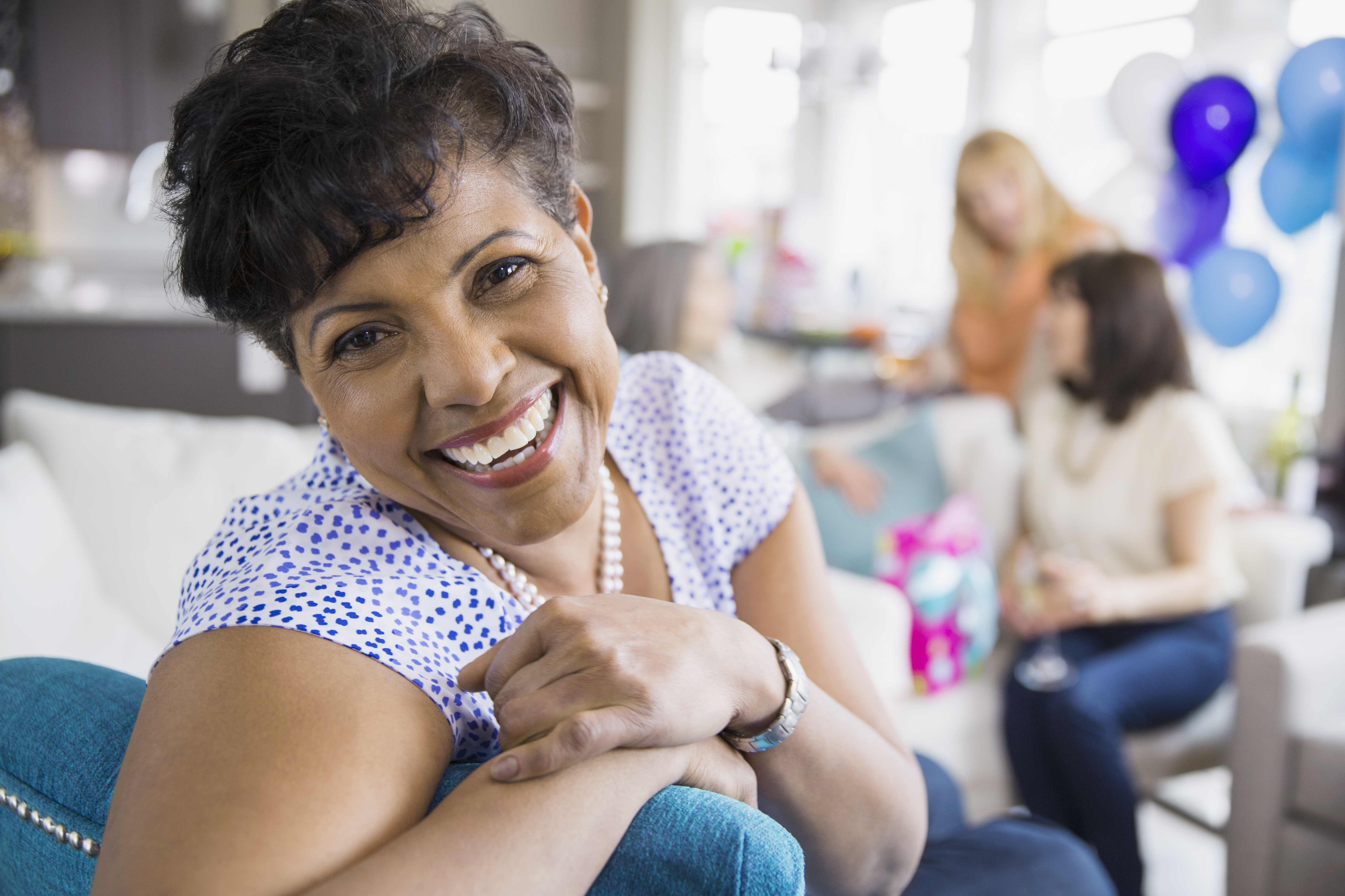 Portrait of smiling woman at party in living room