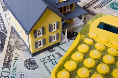 House with twenty dollar bills background and calculator