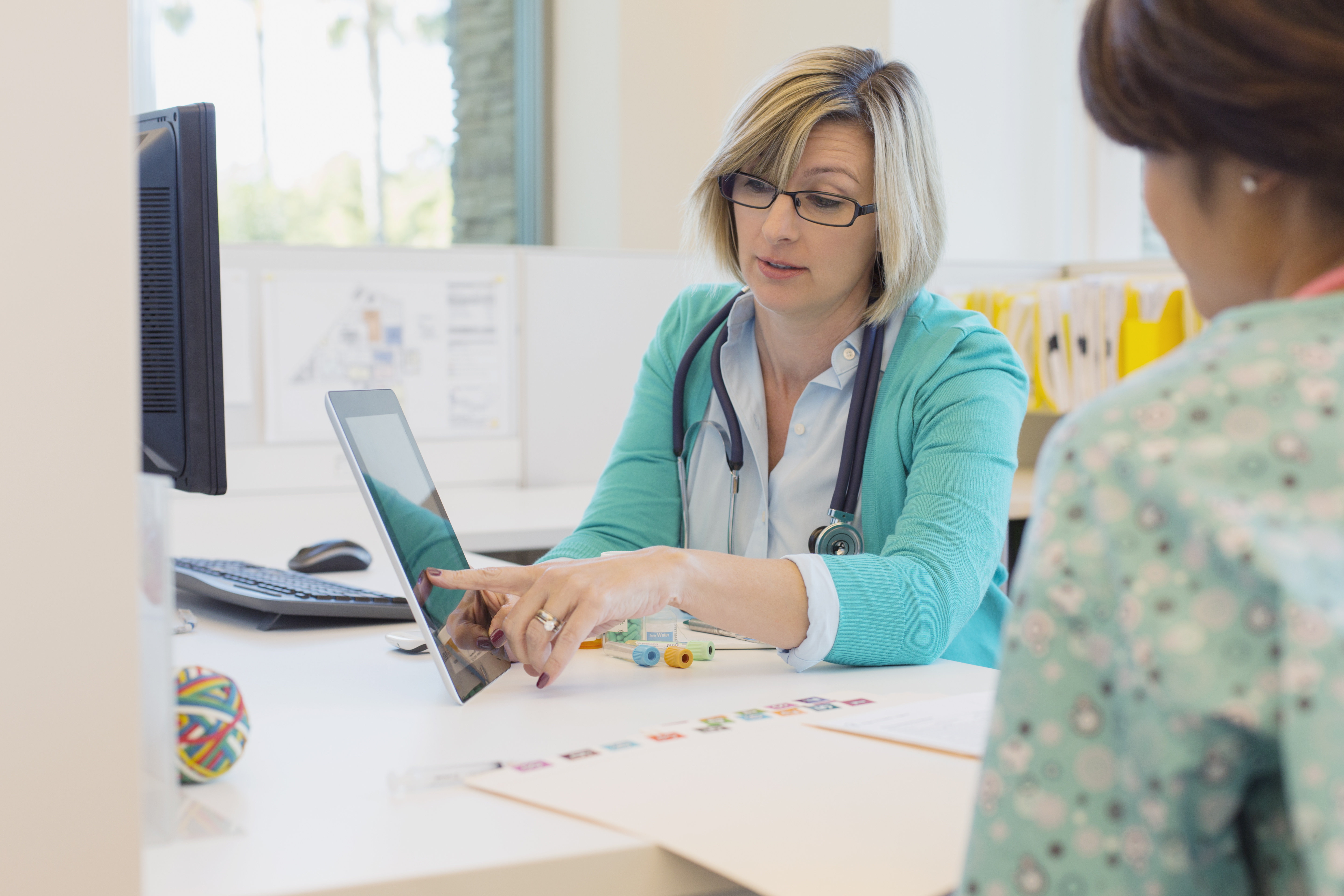 Doctor reviewing medical records with nurse at desk