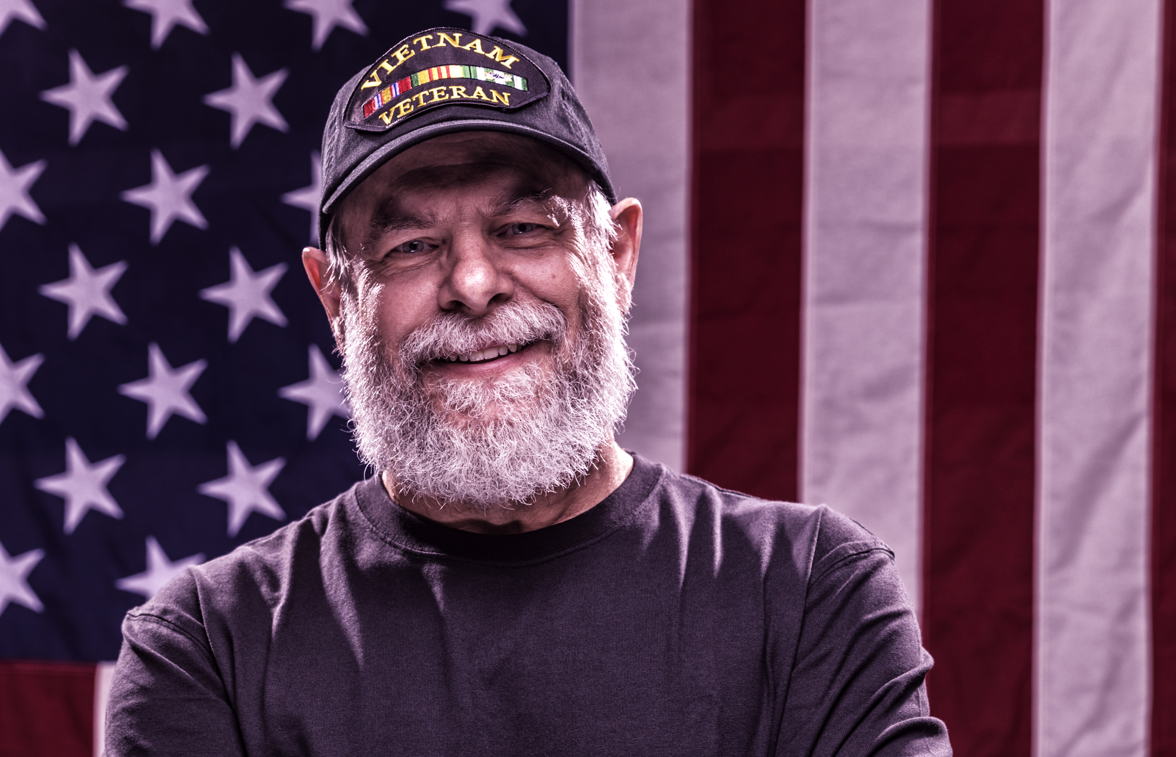 USA Vietnam Veteran With Arms Crossed and American Flag Background