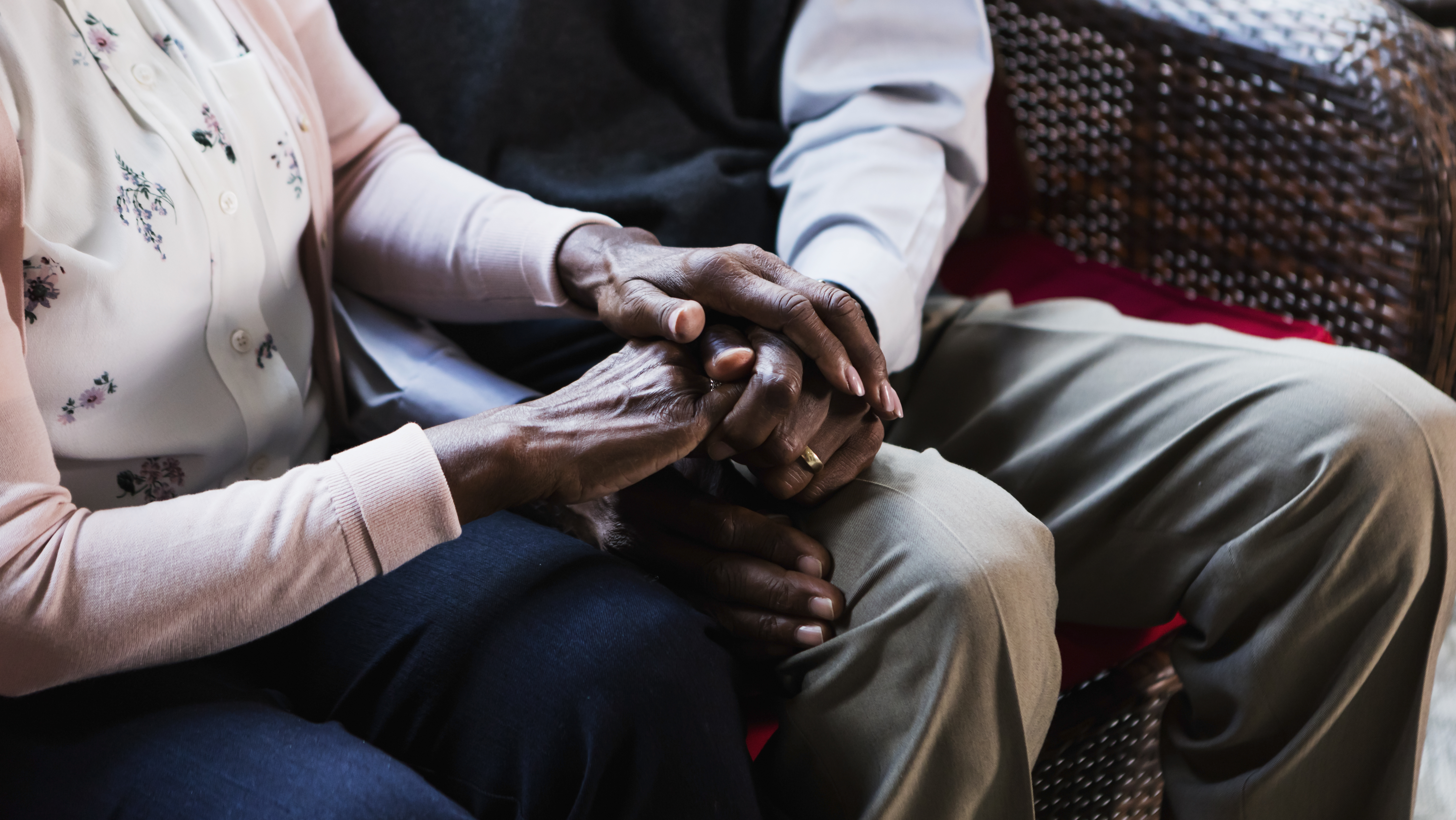 Senior African-American couple sitting, holding hands