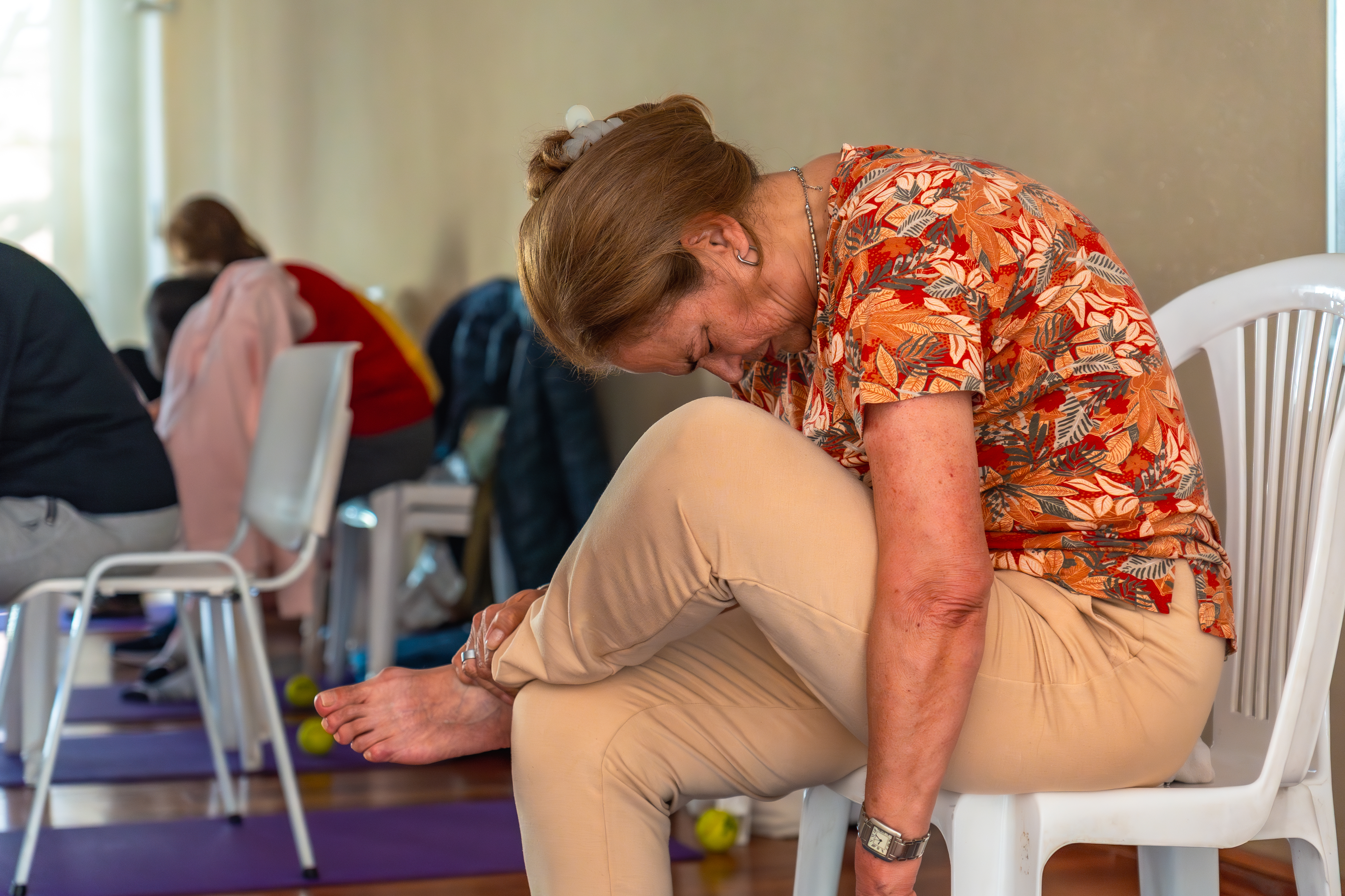 Senior woman sitting in chair relaxed in yoga exercise to stretch the back