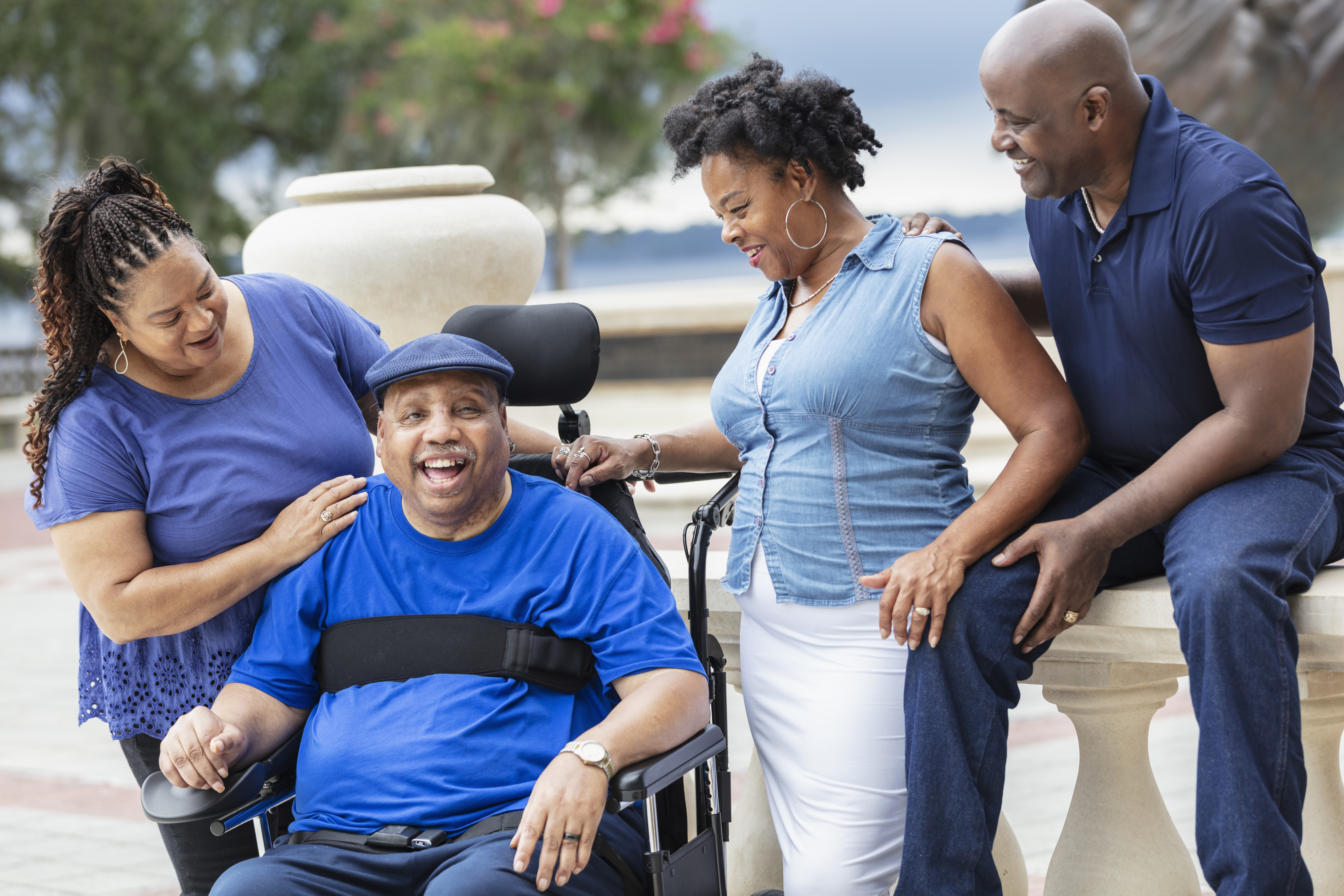 Four African-American seniors at park, man in wheelchair