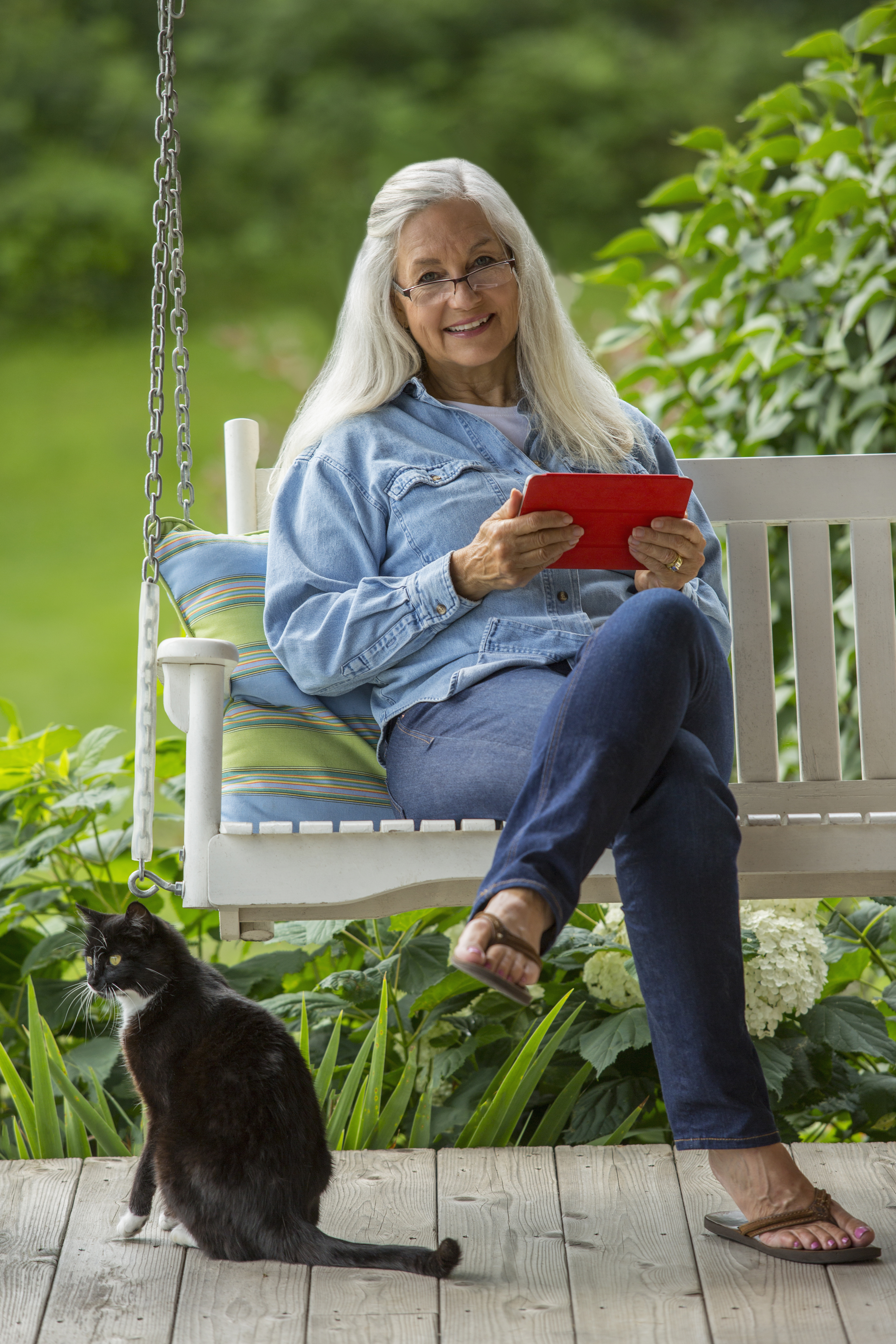 Caucasian woman using digital tablet on porch swing